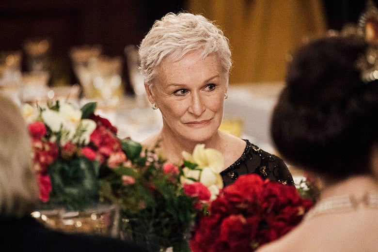 Glenn Close at a banquet table seen behind a flower centerpiece.